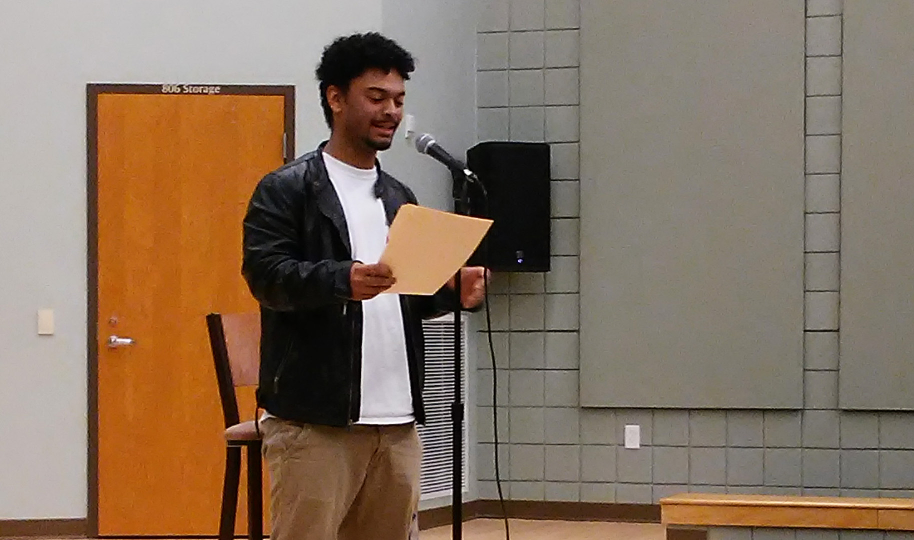 Man talking into a microphone on a stage