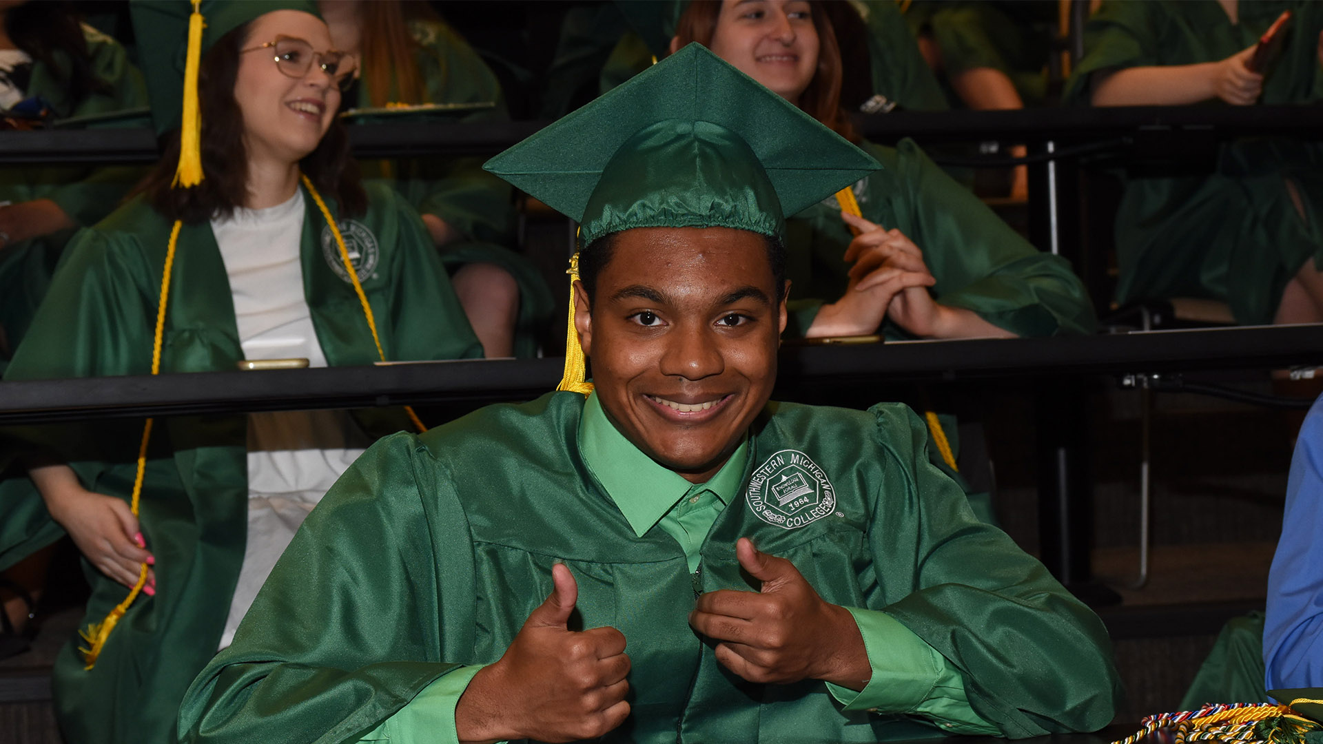 Graduate giving a thumbs up