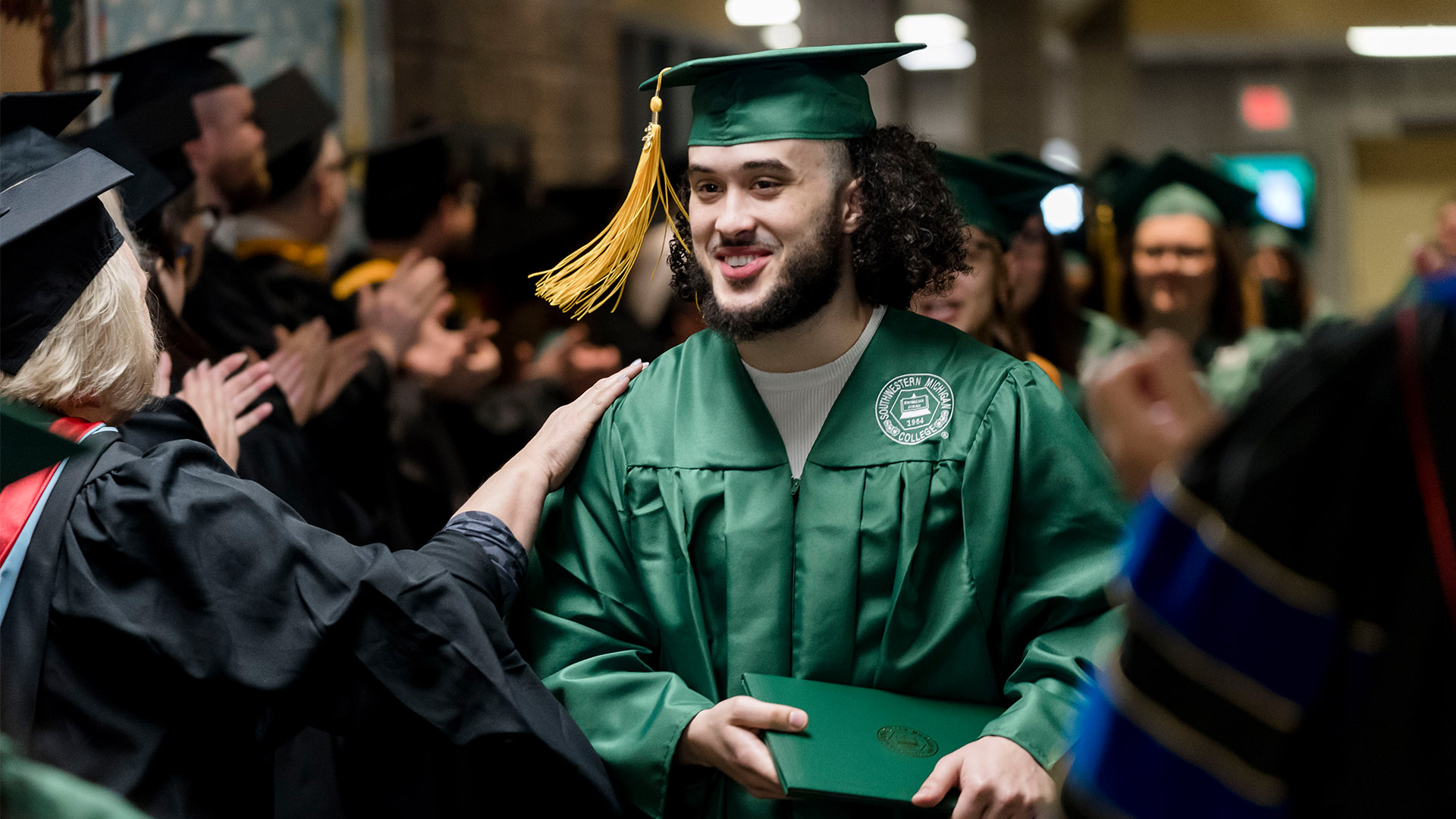 Graduate being congratulated by faculty