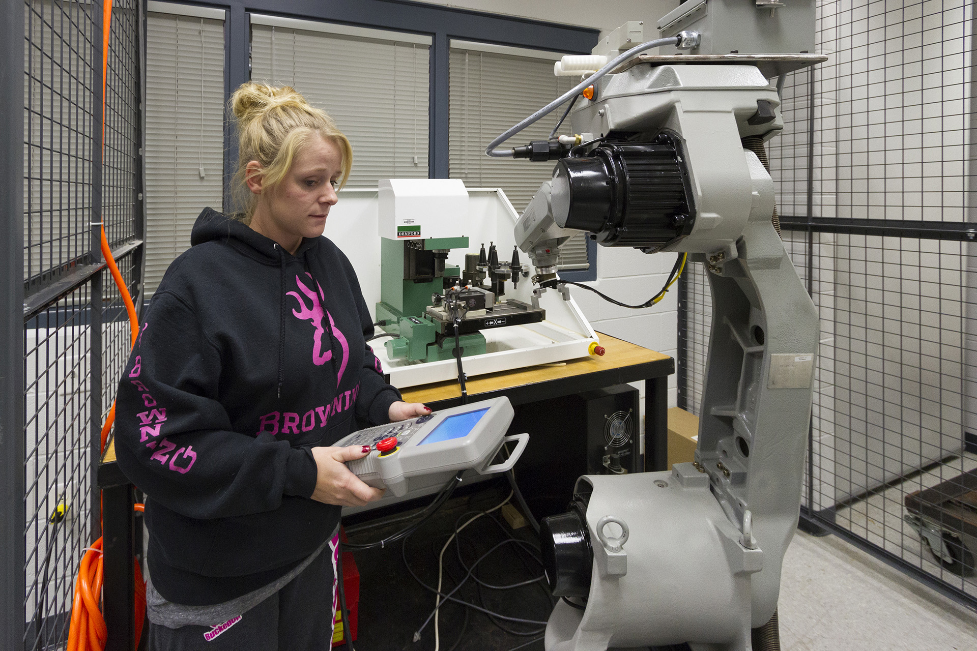 A student operating a robotic arm