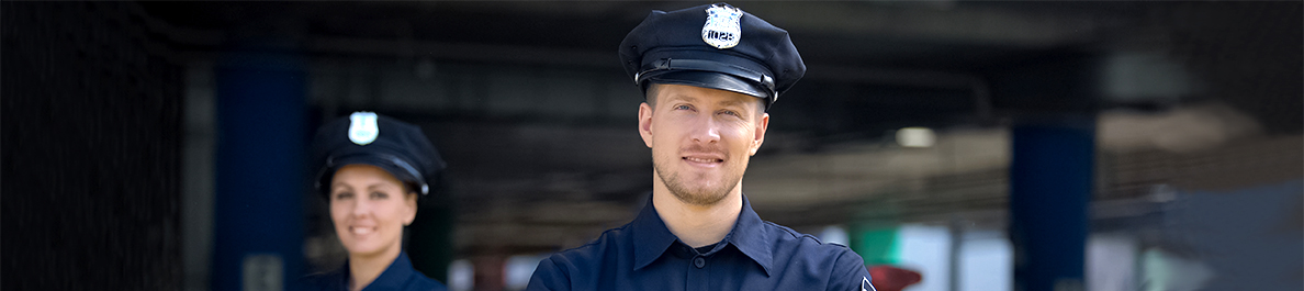 Smiling police officers standing near police station