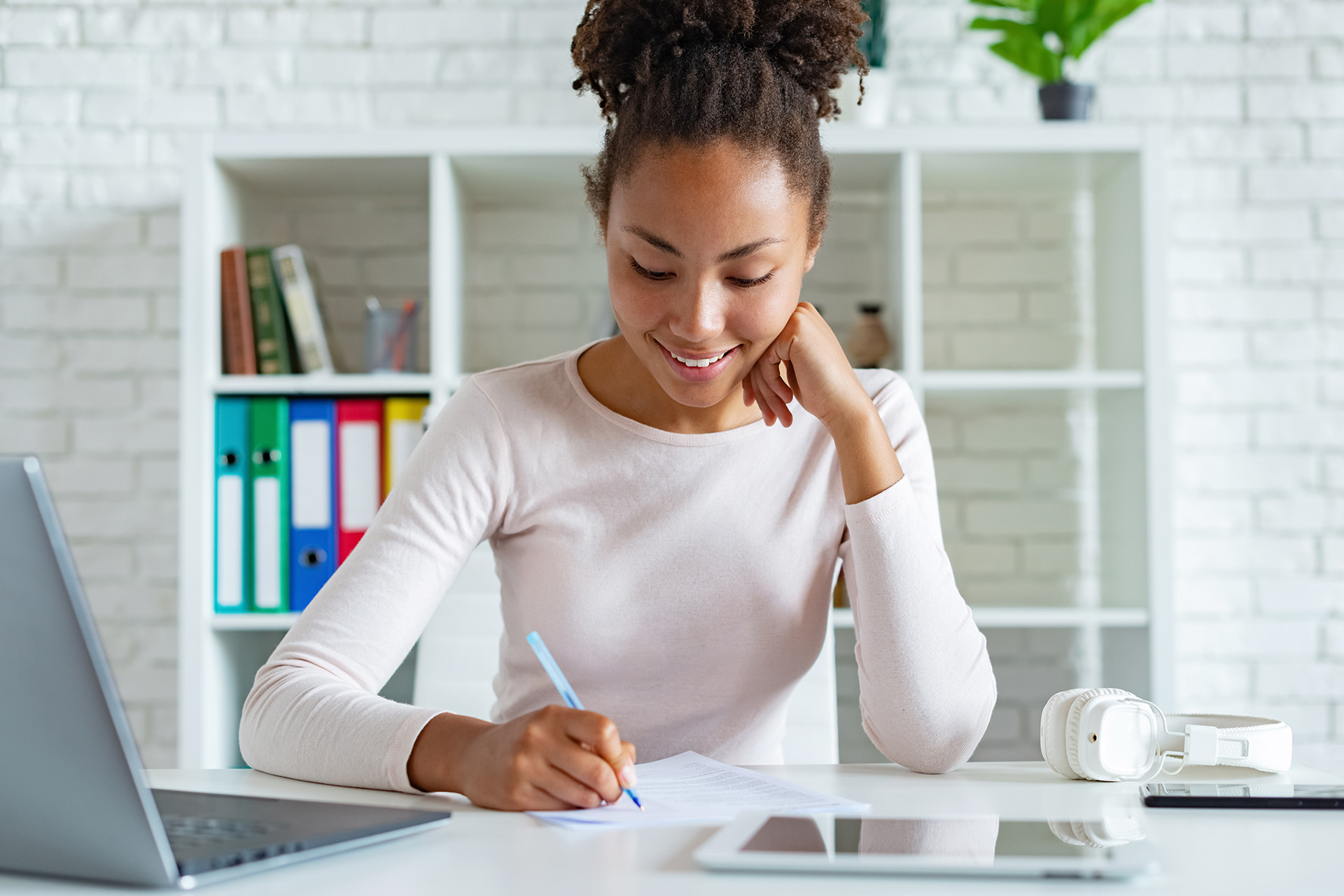 Girl writing in a notebook and sitting at a desk